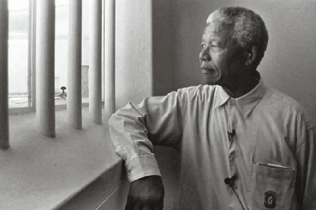 Nelson Mandela looking out the window of his prison cell on Robben Island. Image Credit: Jurgen Schadeberg