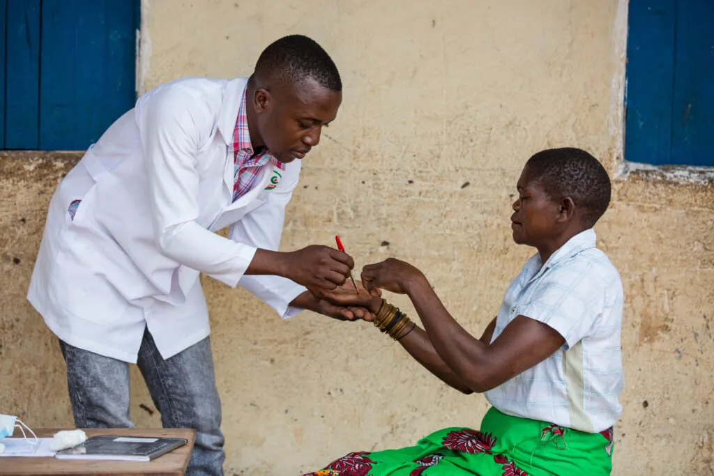 Healthcare worker speaking respectfully with a patient during community outreach.