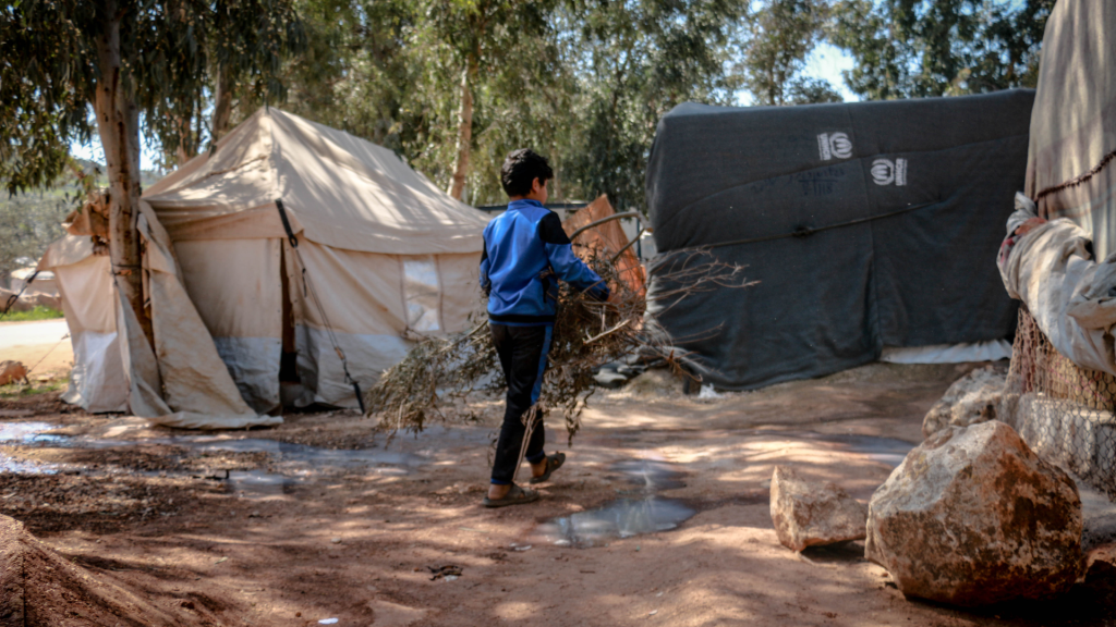 Families traveling with belongings, illustrating displacement and disrupted access to healthcare.