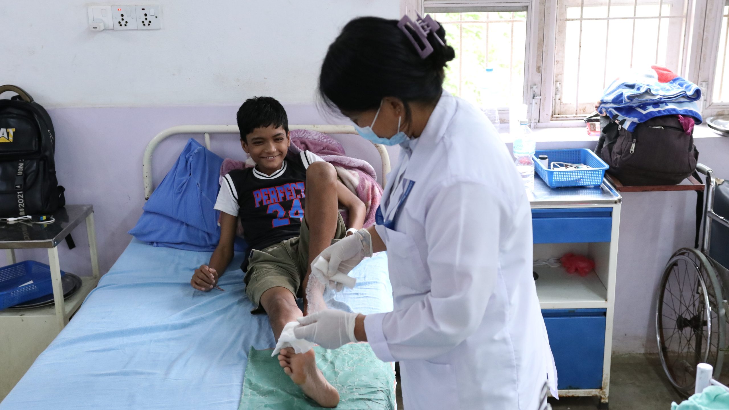 Medical staff provide treatment for Rhitik as he recovers from complications caused by leprosy.
