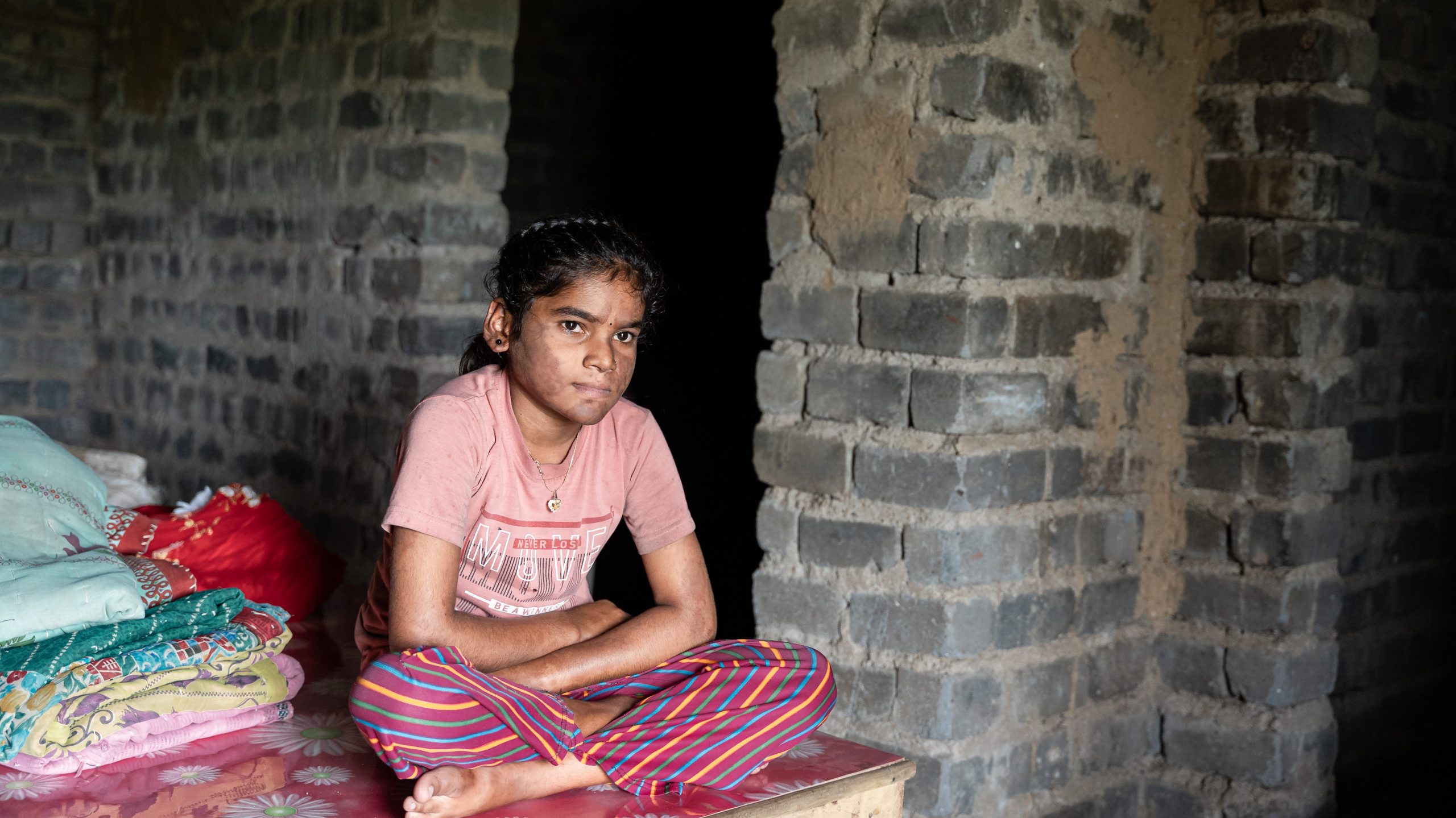Nisha sitting down in her home.