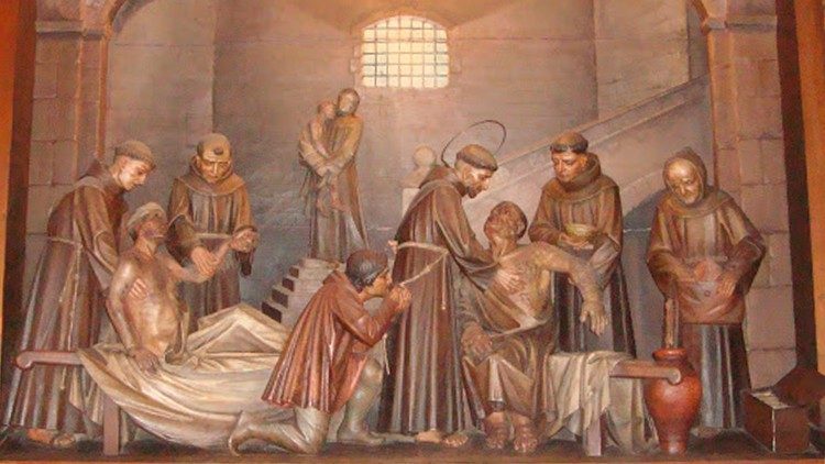 Francis of Assisi, with his friars, helping patients in a hospital - including patients affected by leprosy.